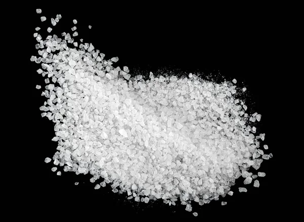 Crystals of sea salt on a black background, top view. Pile of salt.