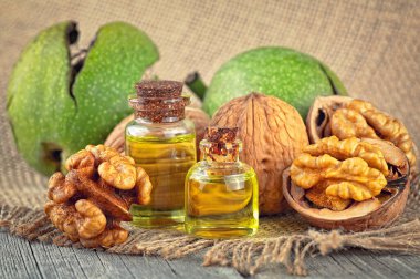 Ceviz çekirdekleri, ceviz ve kırsal ahşap masa üzerinde gerekli ceviz yağı şişeleri. Sağlıklı cevizler..