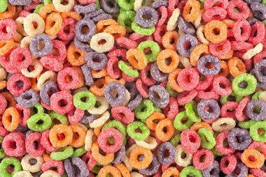 Arka plan olarak tatlı, renkli mısır halkaları, üst manzara. Kahvaltı gevrekleri..