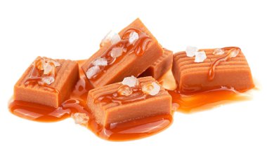 Karamel soslu karamel şekerler ve beyaz arka planda izole edilmiş deniz tuzu. Tuzlu karamel parçaları..
