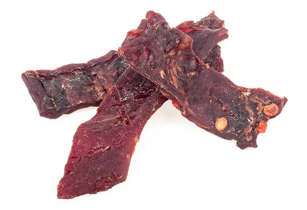 Spicy beef jerky pieces isolated on a white background. Dried jerky meat.