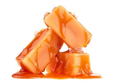 Sıvı karamel soslu lezzetli karamel şekerleri ve beyaz arka planda izole edilmiş deniz tuzu.