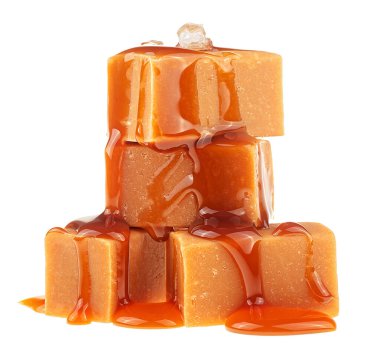 Erimiş sosla kaplı tuzlu karamel şekerleri ve beyaz arka planda izole edilmiş deniz tuzu kristalleri.