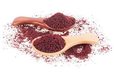Beyaz arka planda izole edilmiş tahta kaşıklardaki yer sumac baharatı. Kurumuş kırmızı Sumac tozu..