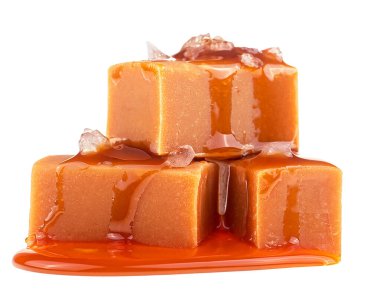 Beyaz bir zemin üzerinde deniz tuzu bulunan lezzetli karamel şekerlemeleri.