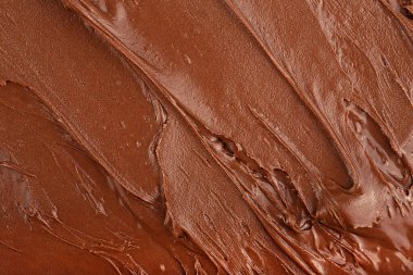 Arka plan olarak erimiş çikolata kreması, üst manzara. Fındık kreması, çikolata lekesi..