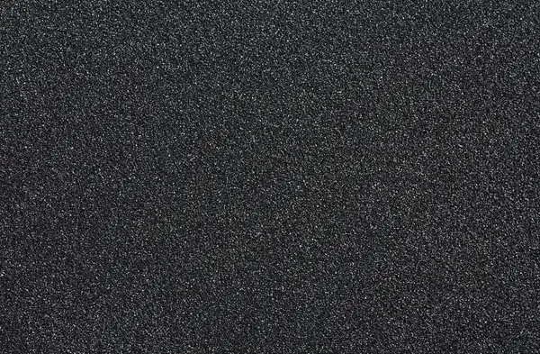 Ezilmiş kuvars - arkaplan olarak siyah kuvars kum, üst görünüm.