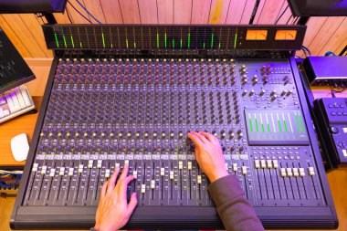 ses mühendisi elleri ses karıştırma konsolu üzerinde çalışıyor. kayıt ve müzik üretim konsepti