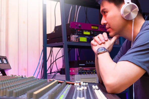 asian male professional music producer, sound engineer working in sound studio. music production concept