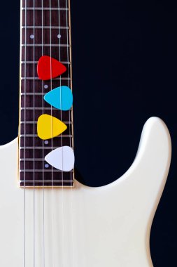 Beyaz elektro gitarda renkli penalar. müzik arkaplanı