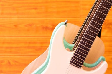 Tahta duvar arka planında üç gitar elektrik ve akustik gitar gövdesinin güzel şekil eğrisini gösteriyor.