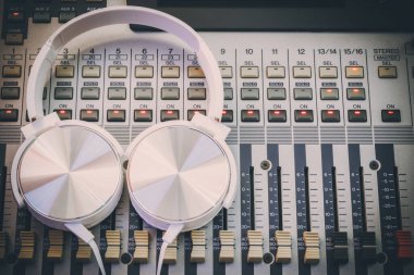 Ses karıştırma konsolunda beyaz kulaklık. müzik arkaplanı, kayıt kavramı