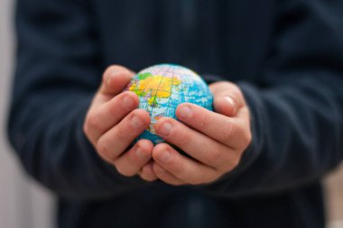 Bir çocuk dünyayı elinde tutuyor. 