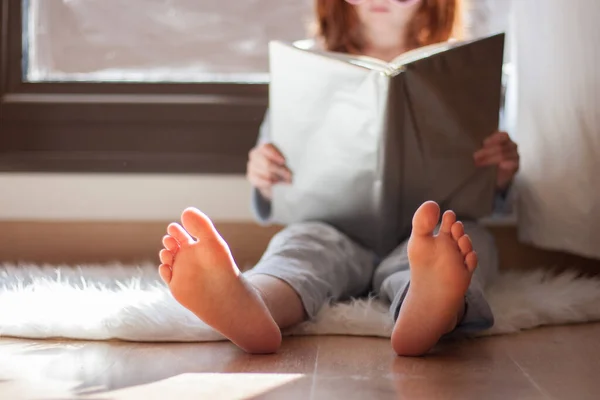 Girl Sitting Bed Reading Book Barefoot Blue Pajamas Window — Stock Photo, Image