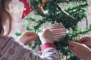 Kardeşler Noel ağacına aile olarak süsleme yapıyor. Yatay olarak. yüzsüz