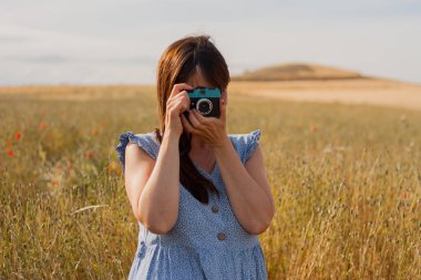 Yetişkin bir kadın fotoğraf çekmek için eski kamerayı kullanıyor. Hobiler. Uluslararası Fotoğraf Günü