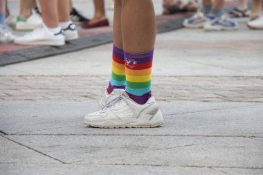 Gökkuşağı spor ayakkabıları tutan tanınmamış kişi. Gurur günü. Yaz. Çamurlu. Yatay