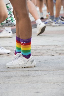 Gökkuşağı spor ayakkabıları tutan tanınmamış kişi. Gurur günü. Yaz. Çamurlu. Yatay