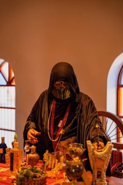 DOHA, Katar - 13 Aralık 2024: Geleneksel siyah elbiseli Katarlı bir kadın Darb Al Saai 'deki Katar Evi' nde oturuyor.