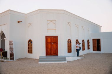 Doha, Katar - 13 Aralık 2024 Darb Al Saai 'de ahşap kapıları ve kepenkleri olan eski bir beyaz miras evi