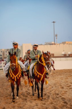 DOHA, Katar - 13 Aralık 2024: Erkekler Katar Ulusal Günü 'nü kutlamak için ata biniyorlar.