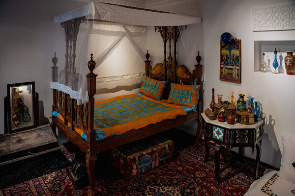 Doha, Qatar - December 13, 2024: Qatar National Day CelebrationsAn old copper bed and a table next to it in a majlis in the Qatari House in Darb Al Saai