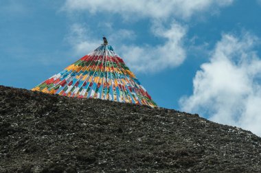 İpler üzerinde renkli dua bayrakları - Vietnam Tso Gölü, Damxung İlçesi, Lhasa, Tibet, Çin 'de rüzgarda dalgalanıyor. Tibetliler, duaların ve mantraların rüzgar tarafından üfleneceğine inanır.