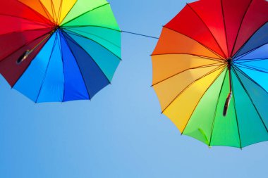 Mavi gökyüzüne karşı iki renkli şemsiye