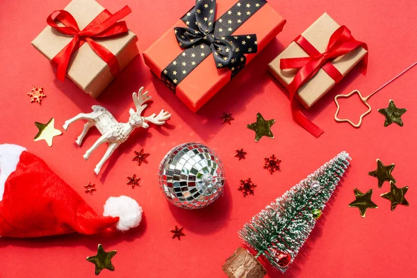 新年大旗 头戴圣诞礼帽 头戴红色背景的圣诞鹿和礼品盒 平铺风格 — 图库照片