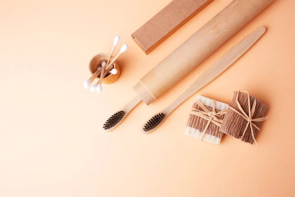 stock image Wooden toothbrushes, natural soap and wooden ear sticks on a beige background. Flat lay style. Natural eco items. Save the Planet