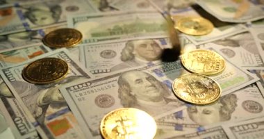 Çevrimiçi iş kavramı. Altın Bitcoin banknotların üzerinde yatıyor.