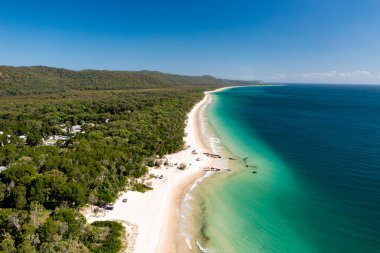 Moreton Adası, Queensland, Avustralya 'daki el değmemiş plajlarda gemi enkazı ve off-road araçları.