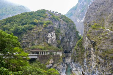 Swallow Grotto Yanzikou Patikası altında dar turkuaz Liwu Nehri Boğazı ve Taroko Ulusal Parkı 'nda yüksek dağ yamacı, Xiulin Kasabası, Hualien, Tayvan