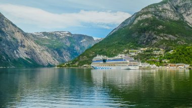 Feribot gemileri Norveç, Geiranger Fjord iskelesine yanaşan turistleri naklediyor.