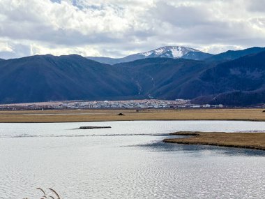 Napahai Grassland Scenic Area And Napahai Lake Surrounded by Snow-Capped Mountain In Shangri-La, Yunnan, China clipart