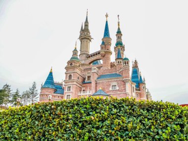 Büyülü Hikaye Şatosu 'nun büyüleyici manzarası Şangay Disneyland, Çin' deki çiçek açan bahar bahçeleriyle çevrili, fantezi ve meraka sihirli bir kaçış.