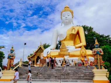 Wat Phrathat Doi Kham, Chiang Mai, Tayland 'da oturan dev Buda heykeli. Muhafız heykelleri ve geleneksel Tayland mimarisi ile çevrili popüler bir hac alanı.
