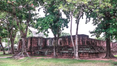 Phimai Tarih Parkı, Nakhon Ratchasima, Tayland 'daki ağaçlarla çevrili antik kumtaşı harabeleri, bu tarihi Budist tapınağı kompleksindeki Khmer mimarisi ile doğa arasındaki uyumu vurguluyor.