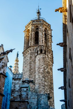 Saint Ivo Kulesi, katedralin bir çan kulesi ve sağdaki heykeller, Barselona, Ciutat Vella bölgesi, Barselona, Katalonya, İspanya, Avrupa Kraliyet Sarayı 'nın bir parçası olan Palau del Lioctinent' ten çıkıyorlar.