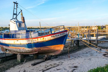 Old fishing boat on shore next to the river Tagus in Lisbon, Portugal, Europe