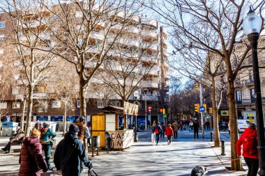 Pedestrians walking in the Winter sun in El Clot, Barcelona, Catalonia, Spain, Europe