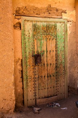 Agdz, Fas, Afrika 'daki bir kerpiç binasının demir kilidi olan eski yeşil kapı.