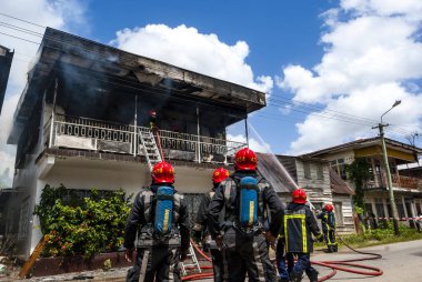 Surinam itfaiyecileri Güney Amerika, Surinam, Surinam, Paramaribo 'nun merkezinde yanan bir evi söndürdüler.