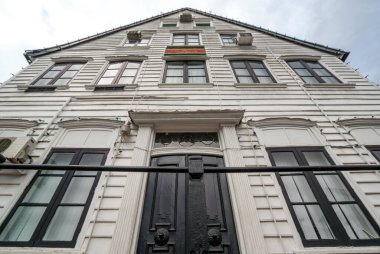 Surinam 'ın bayrağını taşıyan eski beyaz ahşap ev ön cephesinde Paramaribo' nun tarihi merkezi Surinam, Güney Amerika