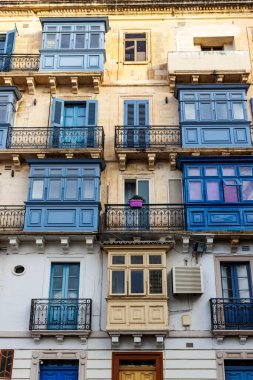 Valletta, Malta, Avrupa 'nın tarihi merkezinde karakteristik mavi pencere ve kapılara sahip eski evlerin cephesi
