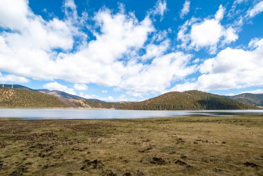 Mountain lake surrounded by trees in Potatso National Park, Shangri La, Yunnan, China, Asia clipart