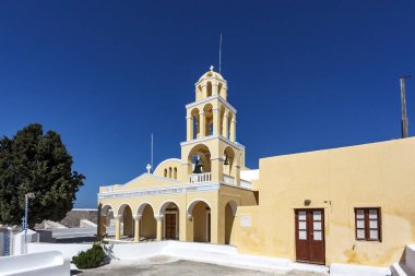 Santorini, Yunanistan ve Avrupa 'da Oia' da (Ia) çan kulesi olan sarı Roma Katolik kilisesi cephesi