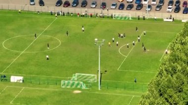 İki profesyonel takımın oynadığı havadan aşağı futbol sahası görüntüsü. Alanın ortasında enerjik bir oyun. Kadın futbolu. Uluslararası şampiyonada önemli bir maç. Güzel hava görüntüsü..