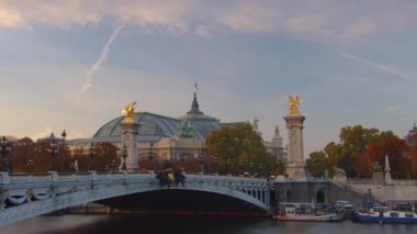 Paris 'teki Alexandre Köprüsü gün batımında aydınlandı. Arka planda Grand Palais. Trafik sıkışık. Paris, Fransa. Zaman aşımı. Yüksek kalite 4k görüntü