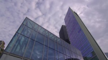 Bulutlar bir iş bölgesindeki aynalı cam gökdelene yansıyor. Şirket işi, yüksek gökdelen cam yüzeyi. Zaman aşımı. Yüksek kalite 4k görüntü